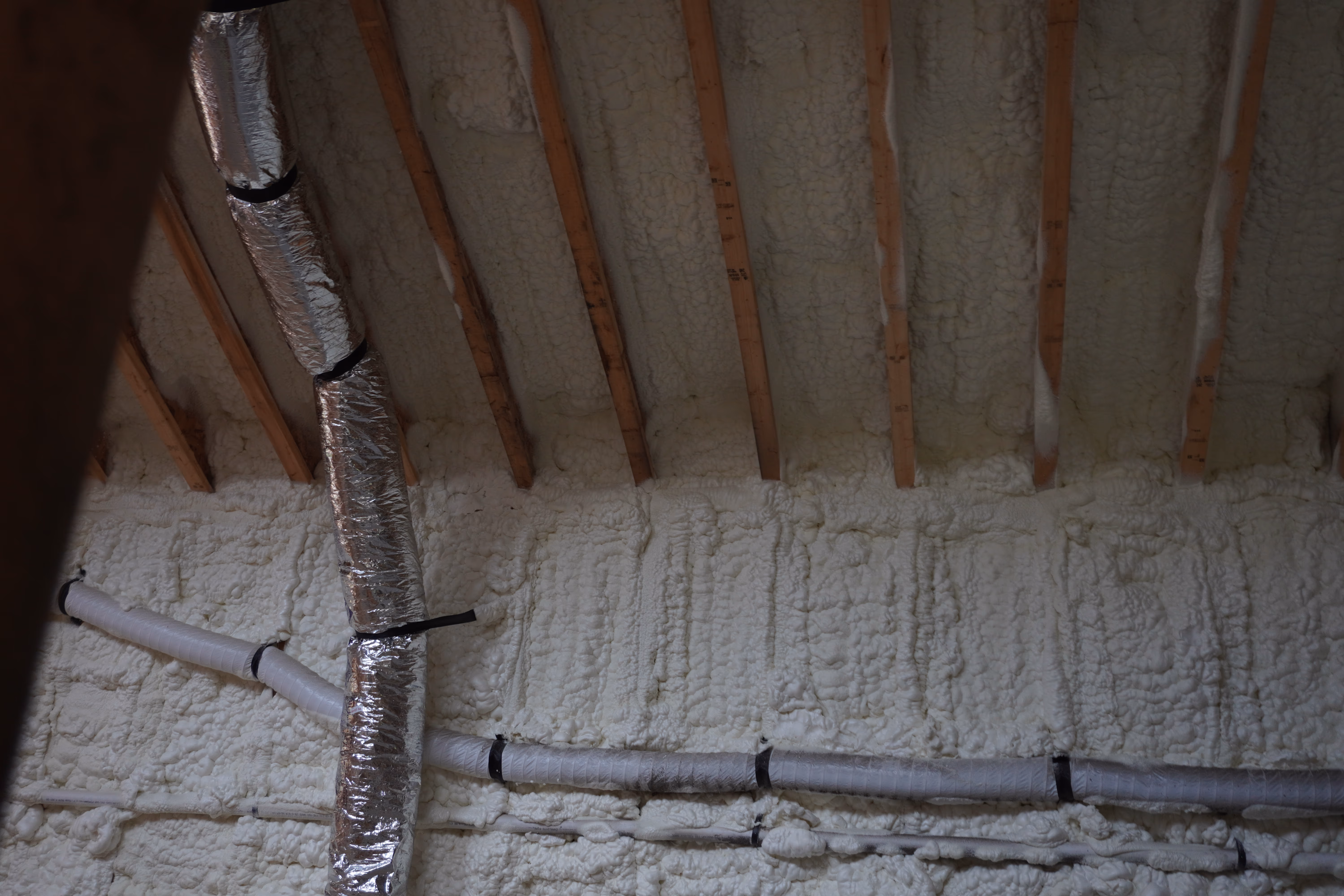 Close-up of spray foam built out between rafters at the roof deck.