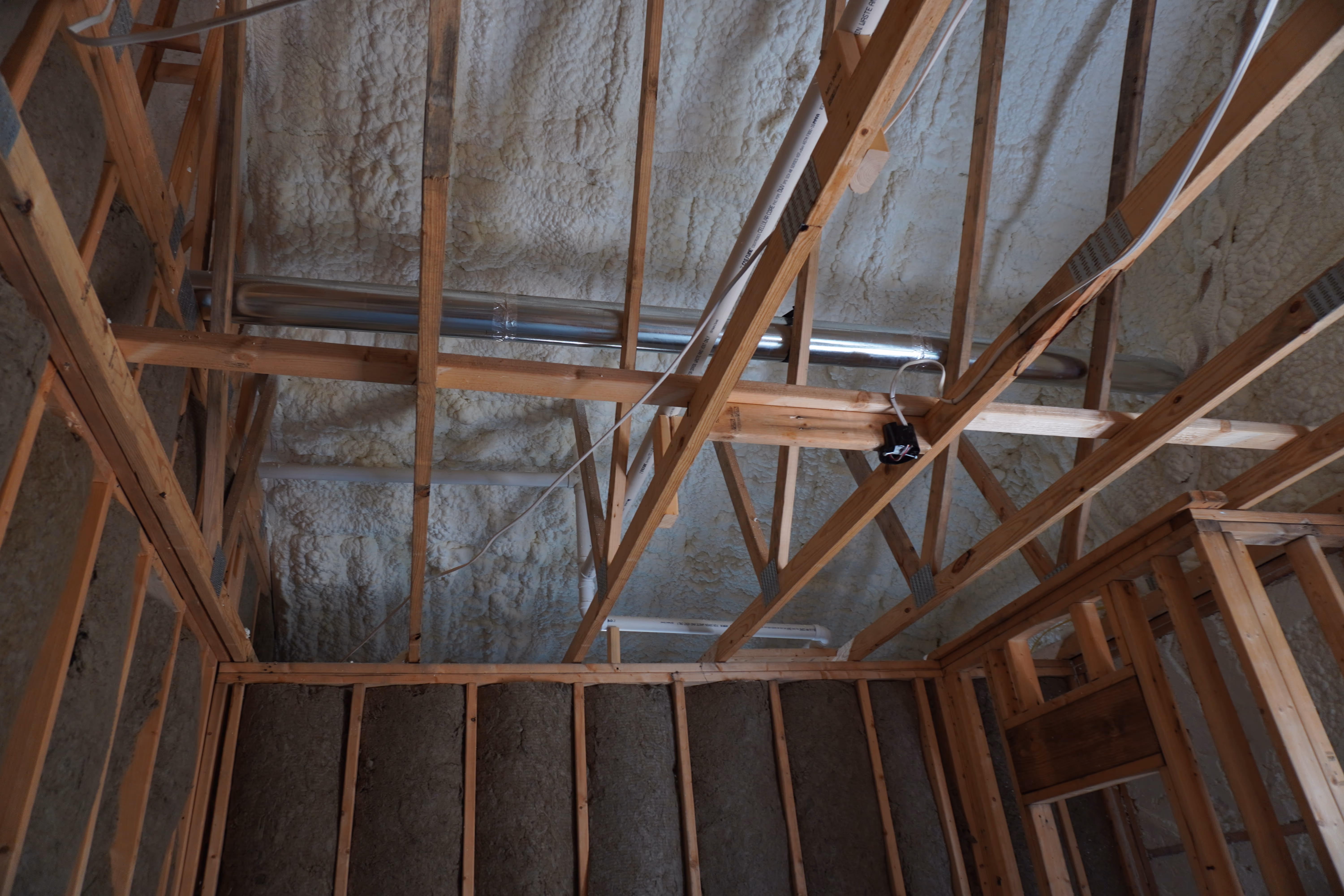 Interior framing insulated with spray foam before the next trade arrives.