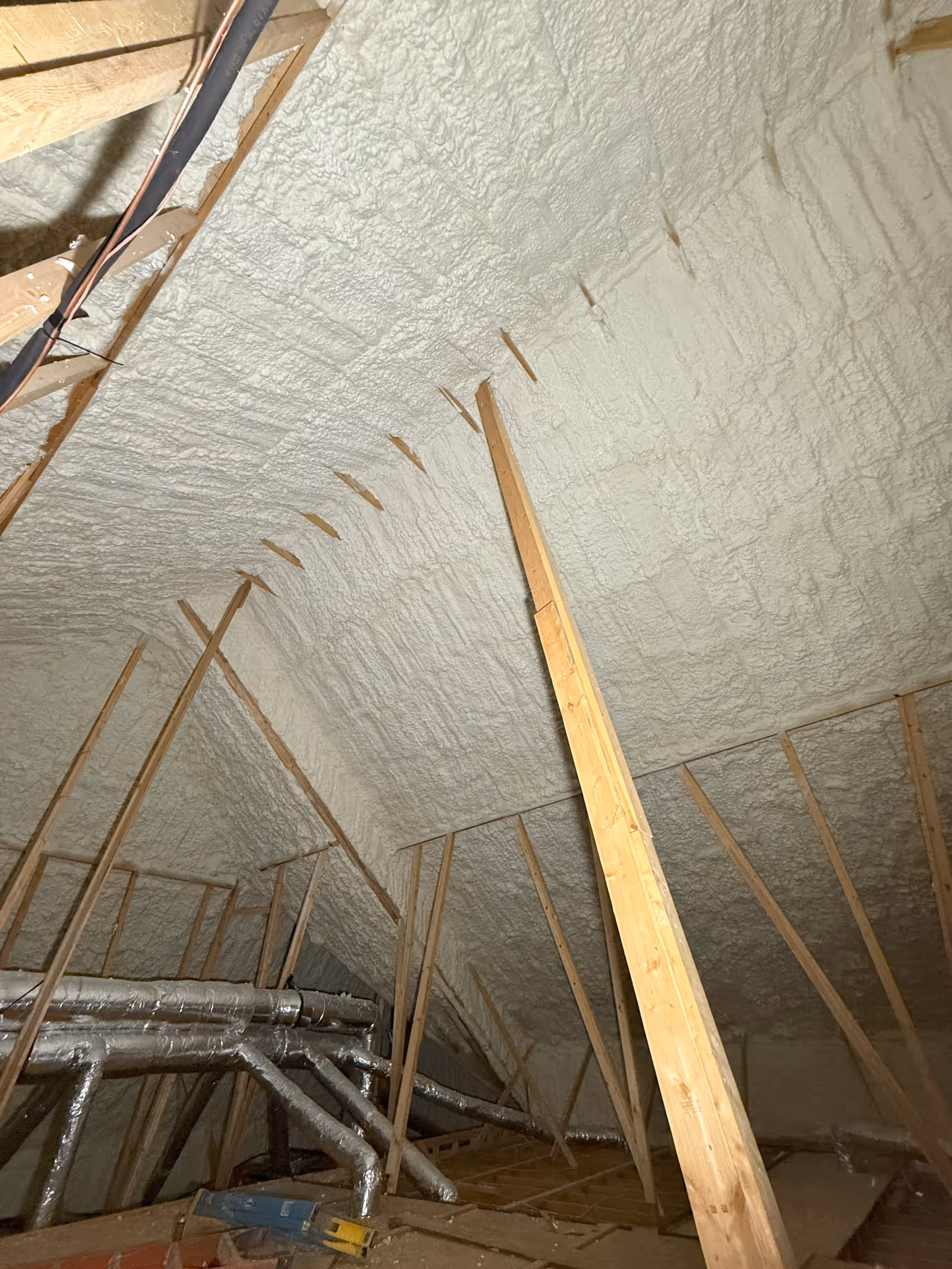 Interior roof framing insulated with spray foam at a Nashville-area project.