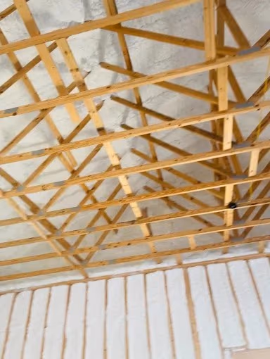 Spray foam roofline detail from a project with exposed rafters.