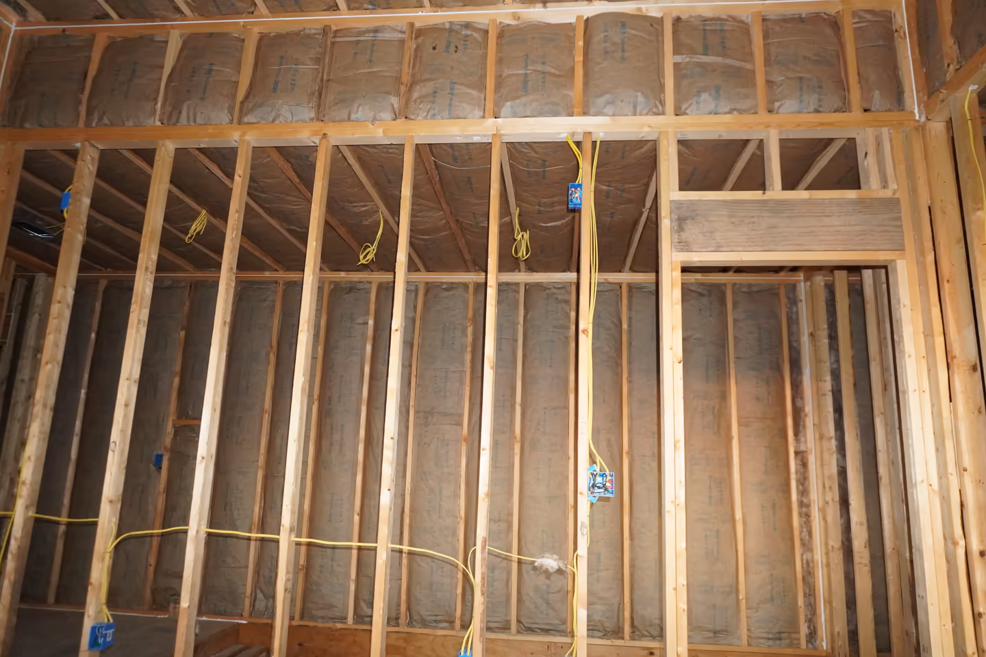 Fiberglass insulation fitted into an interior wall assembly.