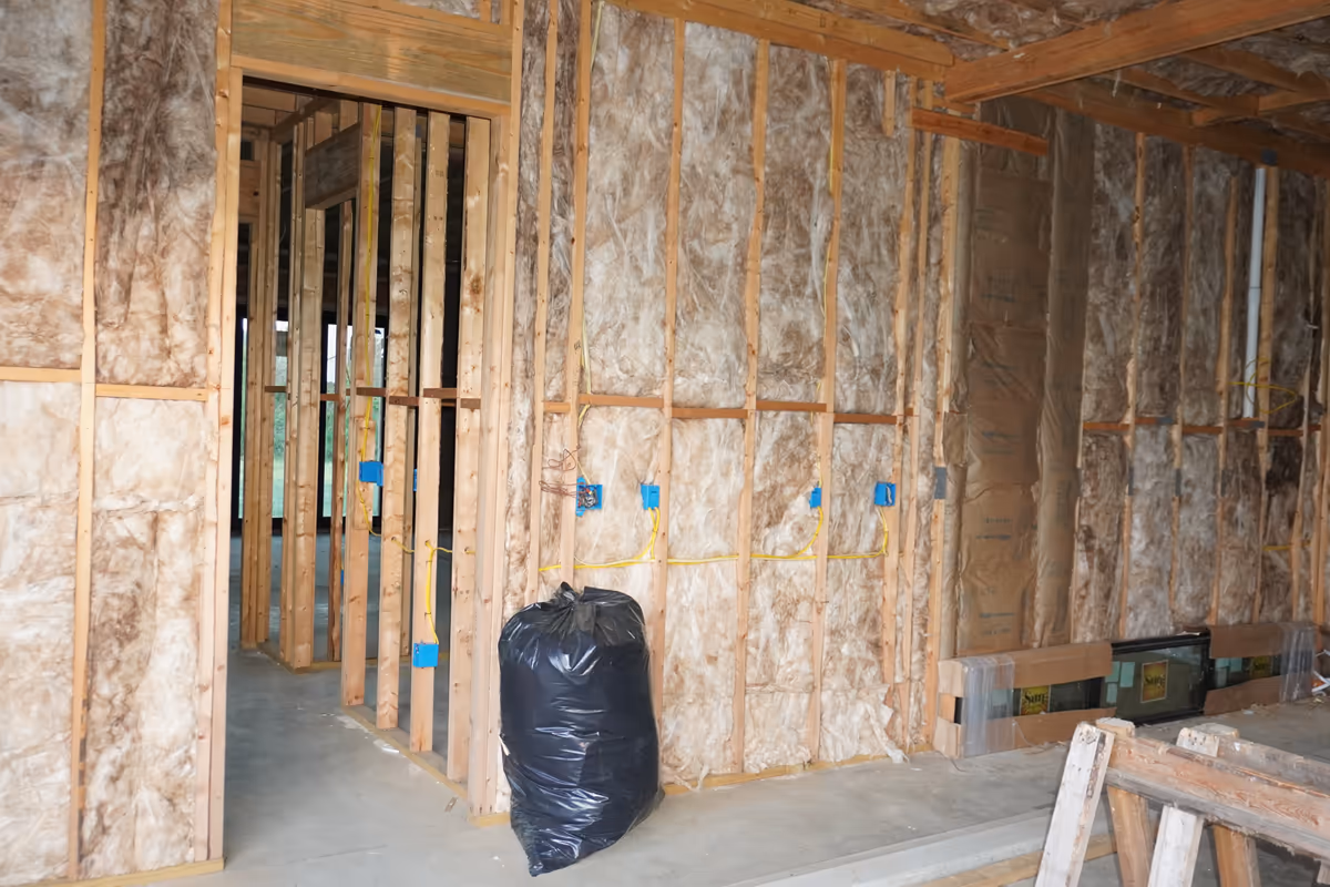 Detail view of fiberglass insulation installed in framed room cavities.
