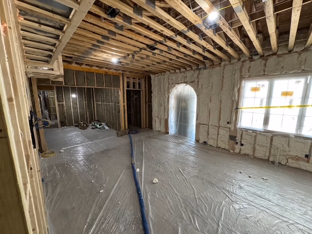Second interior room view showing spray foam coverage across framing.