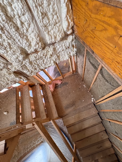 Spray foam coverage following stairwell framing and wall lines.